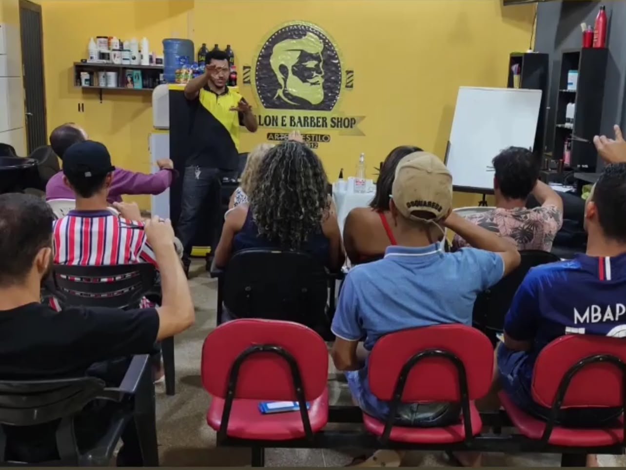 Instrutor orientando aluno do curso de barbeiro